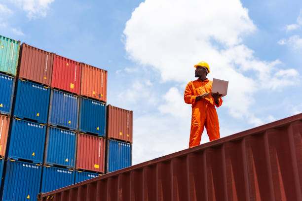 Balck worker using a laptop working in the commercial dock